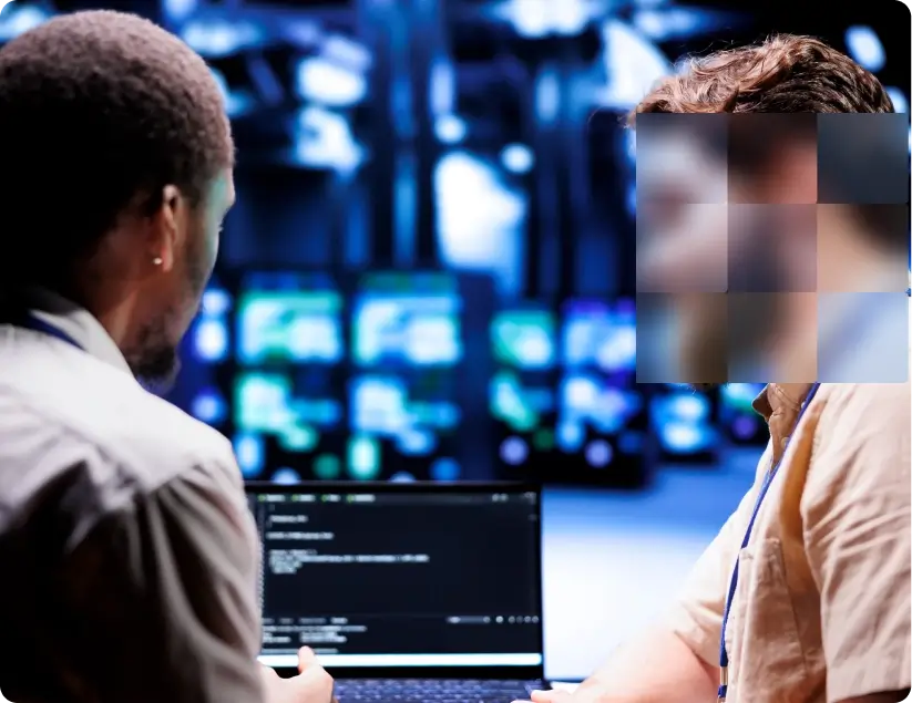 Users with blurred faces looking at laptop